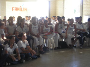 Foto doa alunos assisnto uma apresetação de capoeira