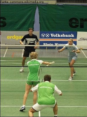 Imagem de um jogo de badminton em duplas.
<br><br>
Palavras-chave: esporte, badminton, raquete.